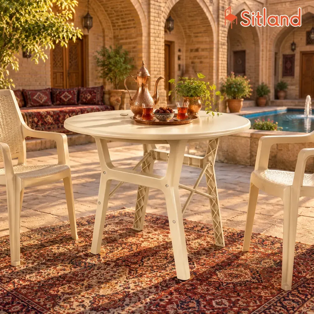 میز گرد پلیمری نیو تیکا کرم روشن با صندلی در حیاط سنتی کاروانسرای کویری با سرویس چای ایرانی و فرش اصیل